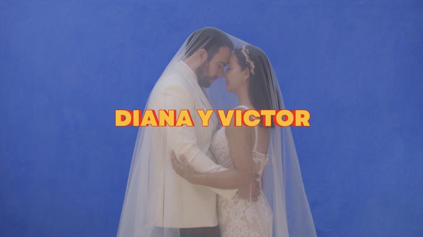 Diana y Victor bajo el velo frente a un muro azul